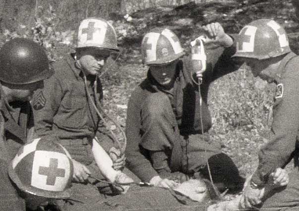 Four medics from the 10th Mtn Medical Bn tend to a wounded soldier